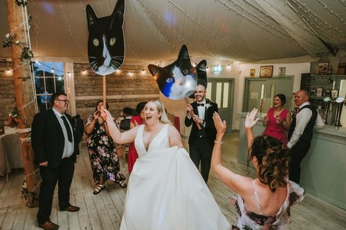 Sarah and I holding posters of our cats as we dance into the room.
