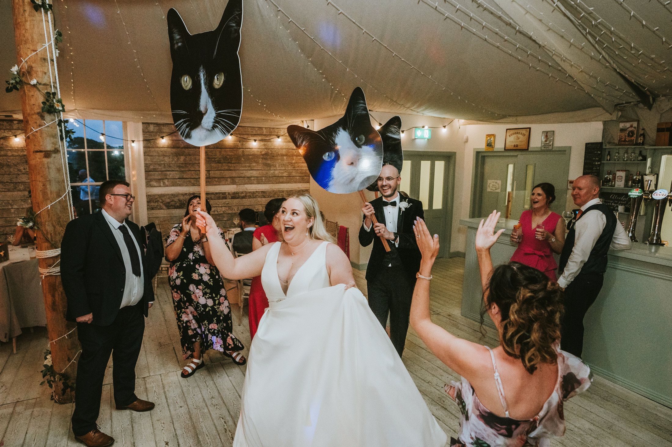 Sarah and I holding posters of our cats as we dance into the room.